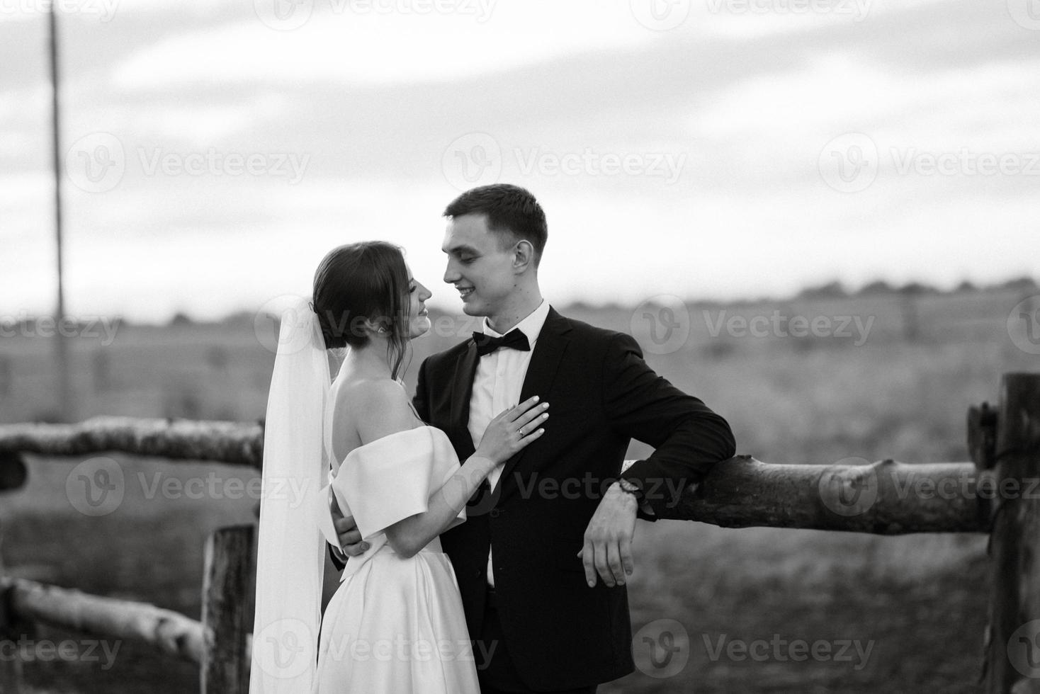 young couple the groom in a black suit and the bride in a white short dress photo