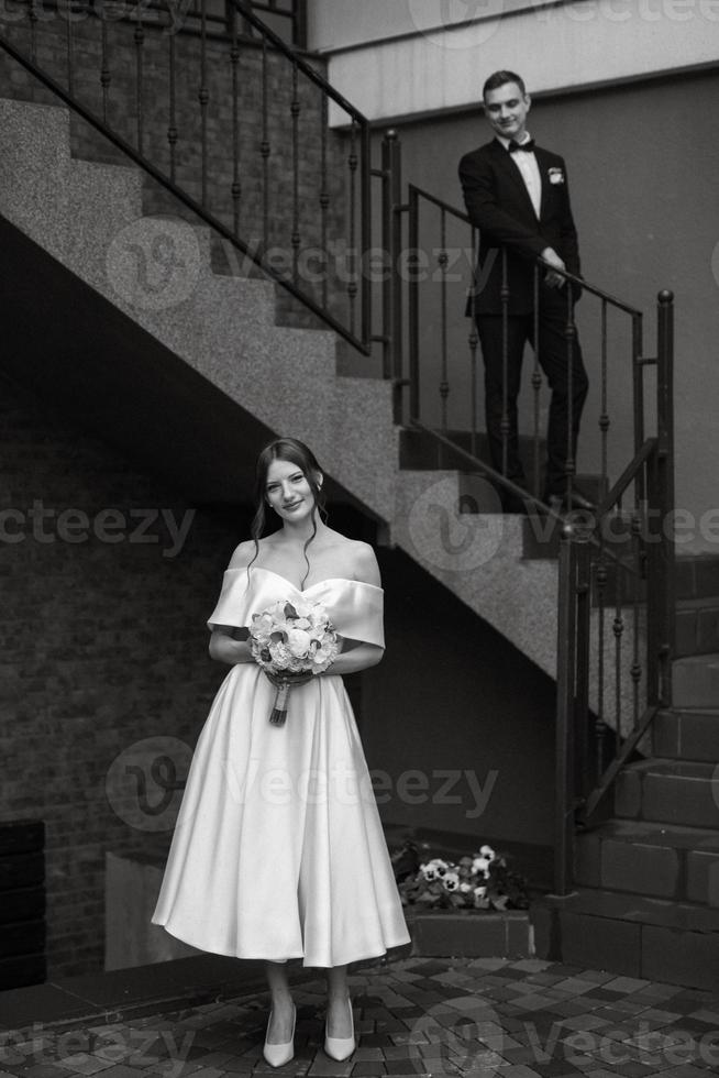 young couple bride and groom in a white short dress photo