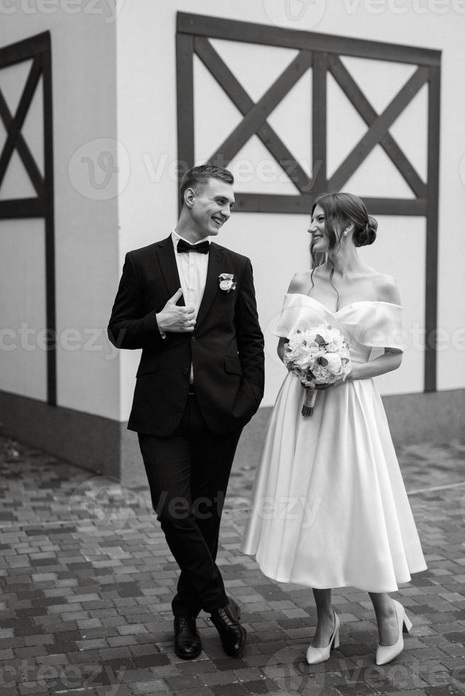 young couple bride and groom in a white short dress photo