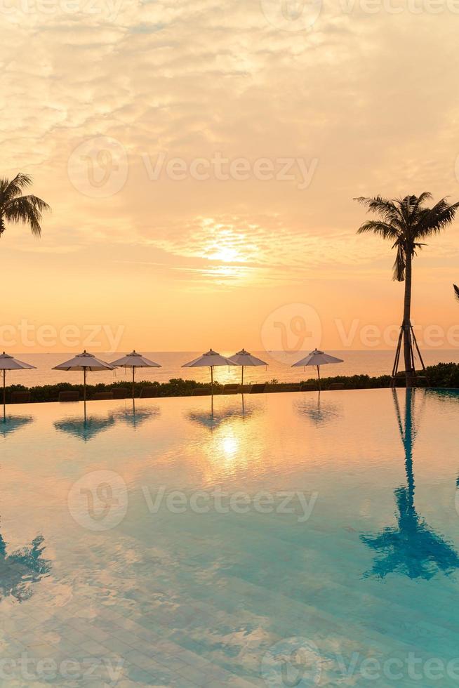 umbrella with bed pool around swimming pool with ocean sea background photo