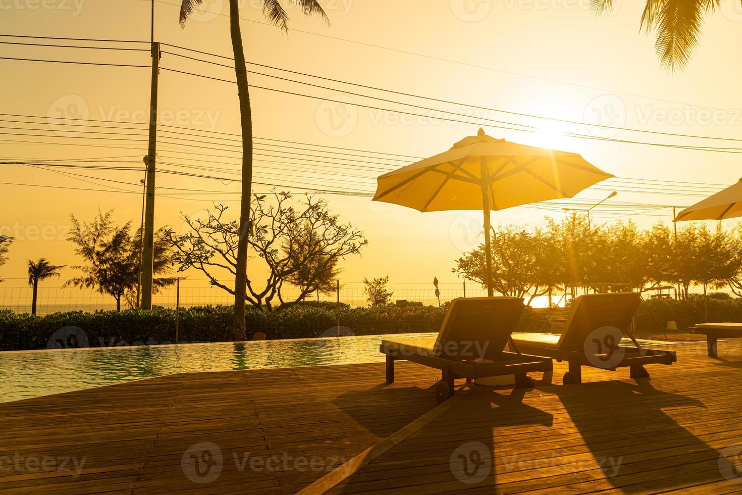 umbrella with bed pool around swimming pool with ocean sea background photo