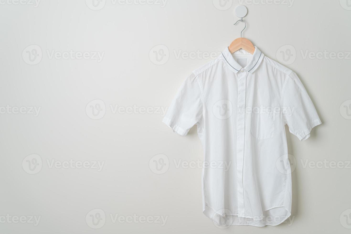 hanging shirt with wood hanger on wall photo