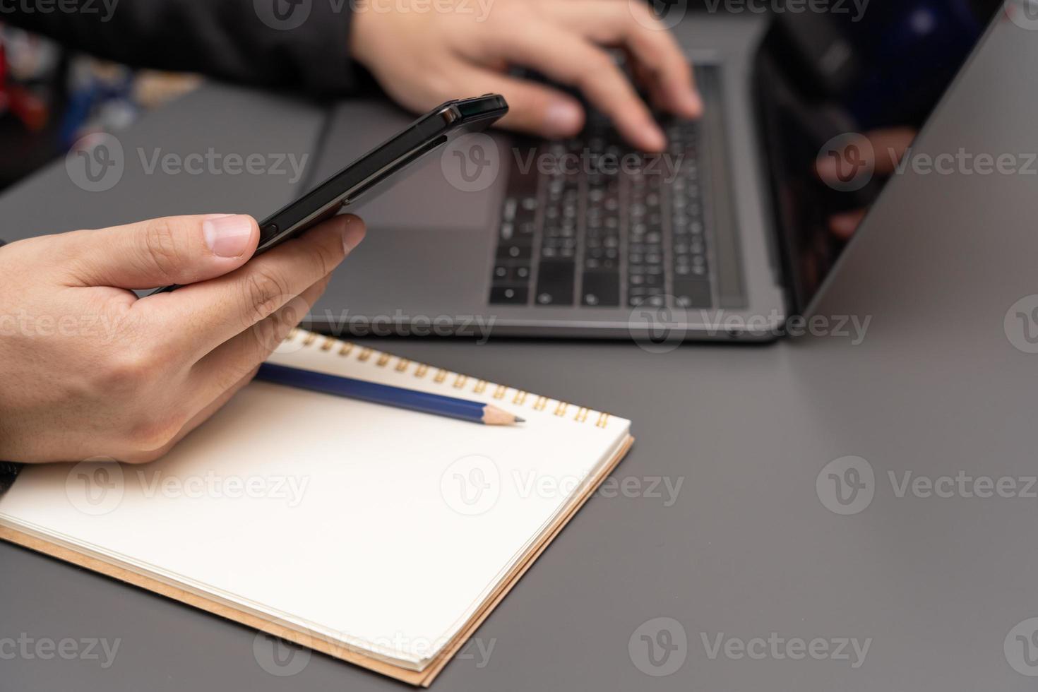 Selective focus, business people hand in suit writing on notebook or using smartphone. A businesswoman writing a note photo