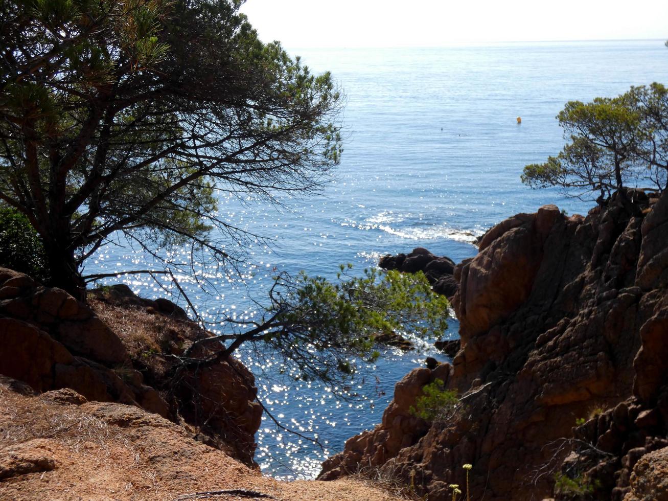 rocks and cliffs with blue sky and turquoise sea photo