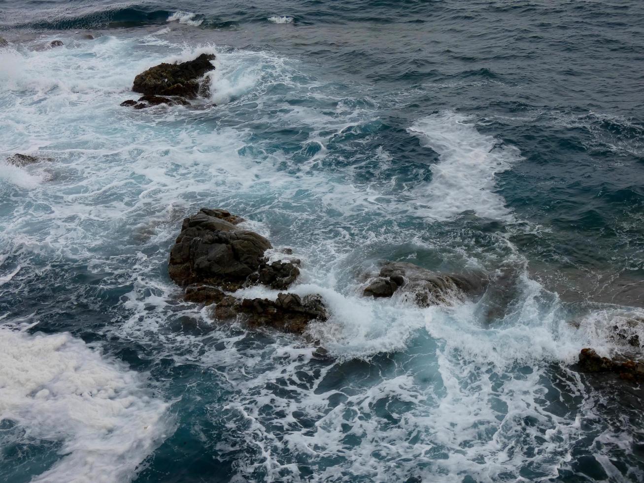 Rough sea, waves crashing against the rocks photo