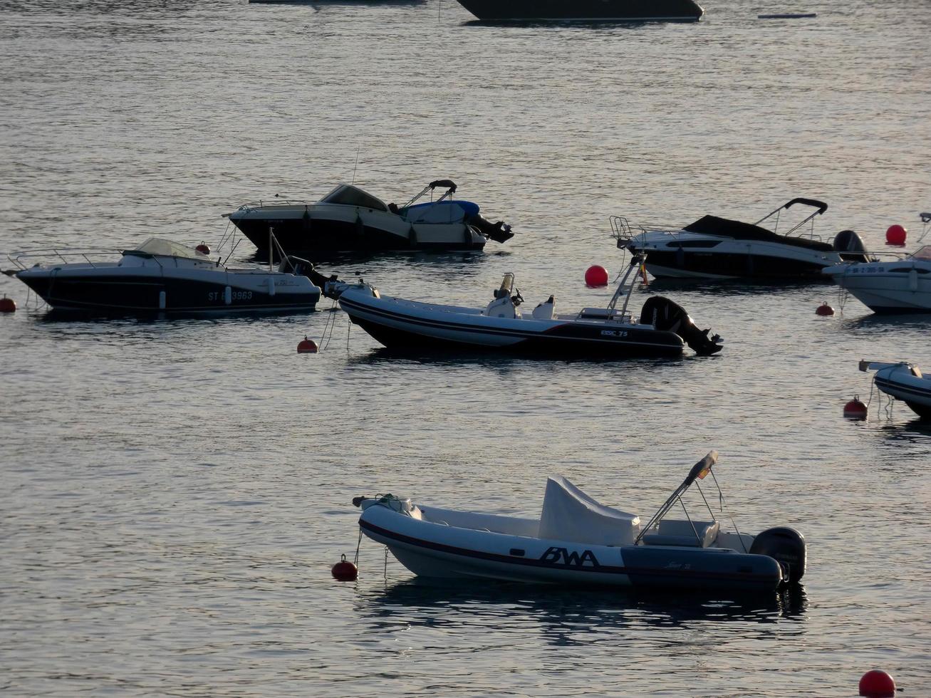 pequeñas embarcaciones de recreo y deportivas fondeadas en medio de la bahía de la costa brava catalana. foto