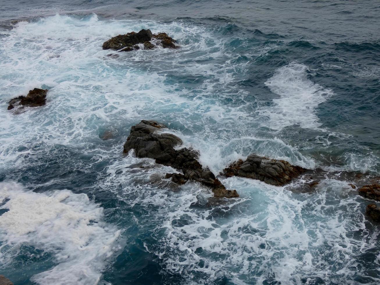 Rough sea, waves crashing against the rocks photo