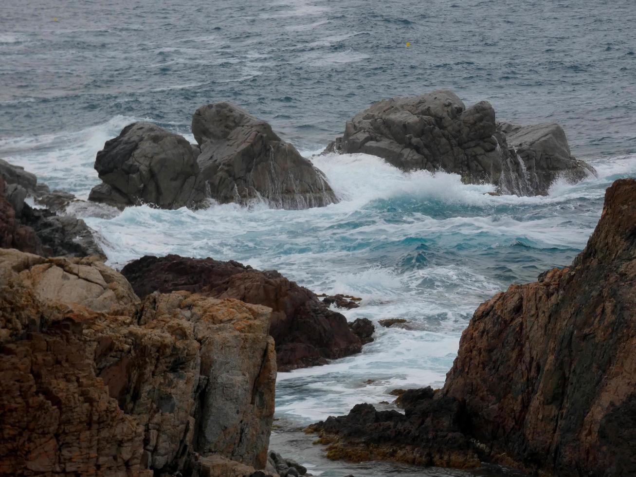 Rough sea, waves crashing against the rocks photo