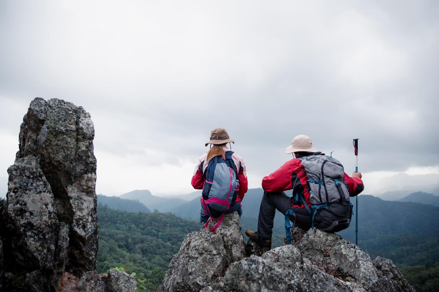 pareja de jóvenes turistas viendo espectaculares paisajes montañosos en alta montaña. excursionista de hombre y mujer en la roca superior. una pareja de viajeros enamorados. la gente saluda al amanecer. los amantes viajan. copie el espacio foto