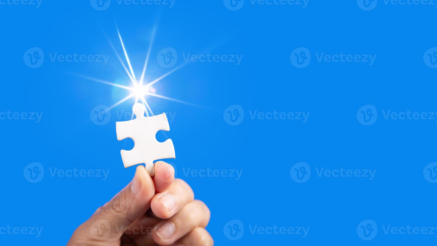 Hands holding jigsaw puzzles piece with clear blue background, success business, solution strategy, teamwork partnership concept photo