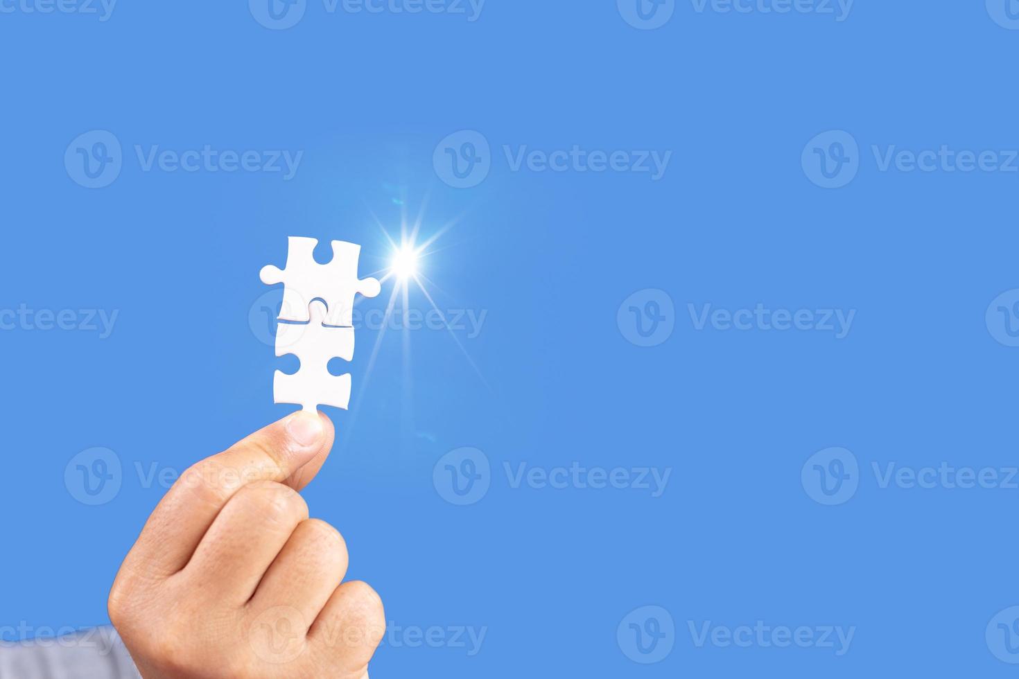 Hands holding jigsaw puzzles piece with clear blue background, success business, solution strategy, teamwork partnership concept photo