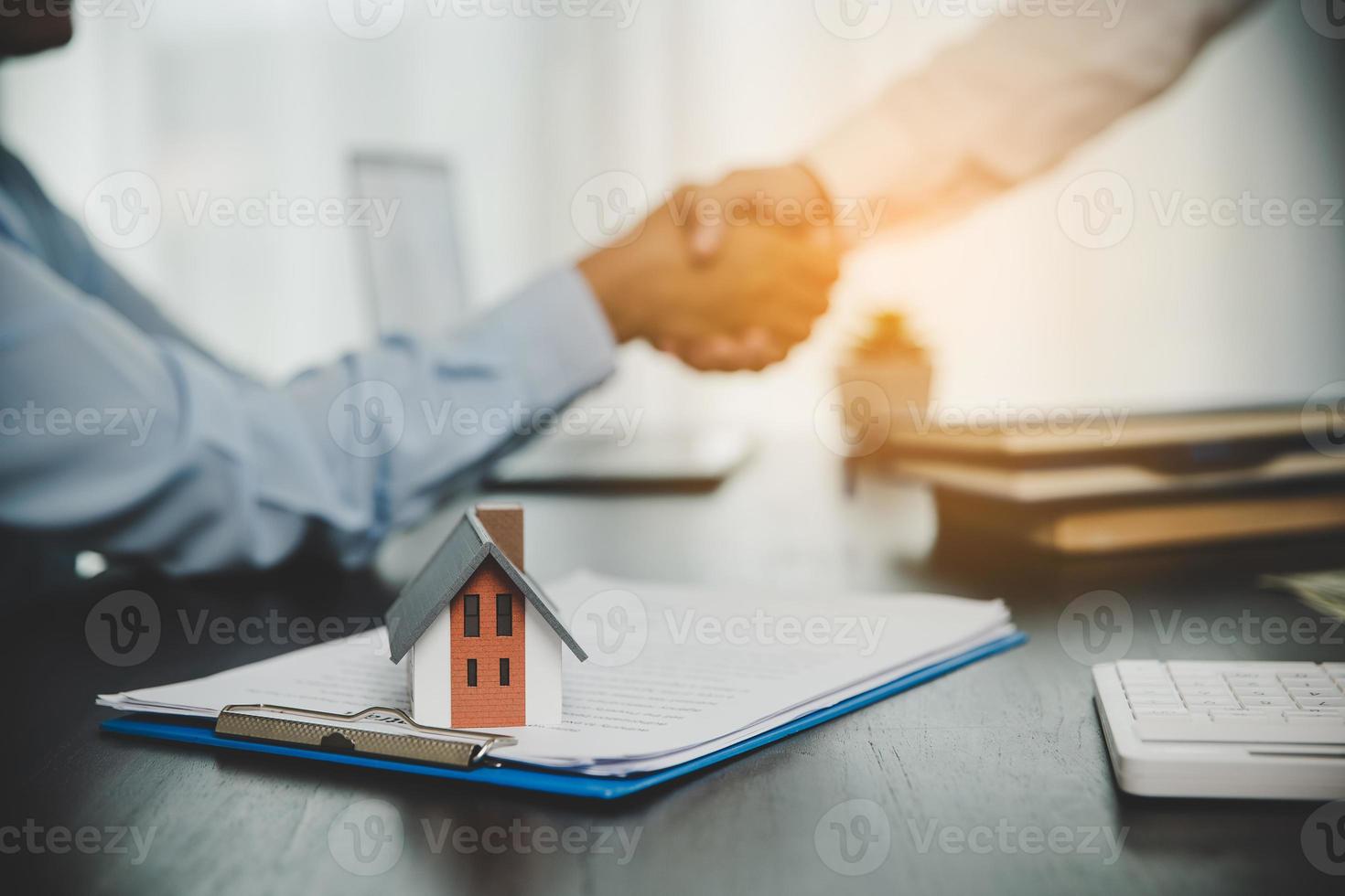 agente inmobiliario estrechando la mano con el cliente después de la firma del contrato y hecho un trato comercial para transferir el derecho de propiedad. hombre corredor agente inmobiliario agente de bienes raíces estrechar la mano de clientes felices propietarios foto