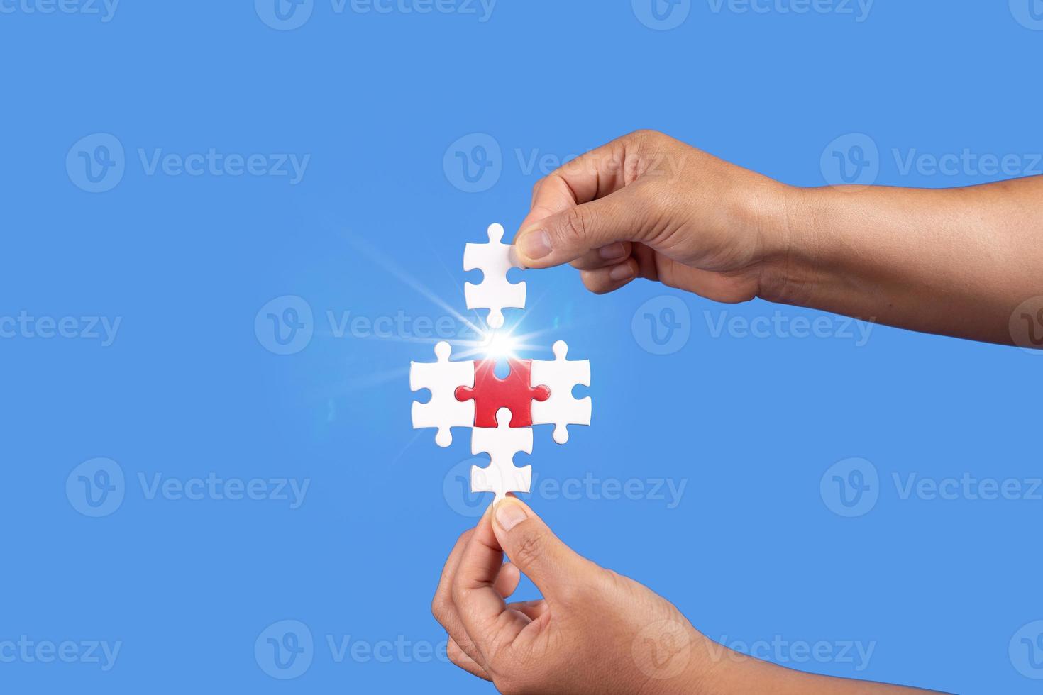 Hands holding jigsaw puzzles piece with clear blue background, success business, solution strategy, teamwork partnership concept photo