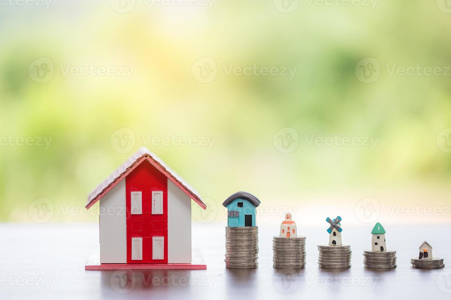 modelo de casa y pilas de monedas de dinero con fondo de naturaleza borrosa. planes de ahorro para vivienda, préstamo, inversión, hipoteca, finanzas y banca sobre el concepto de casa. foto