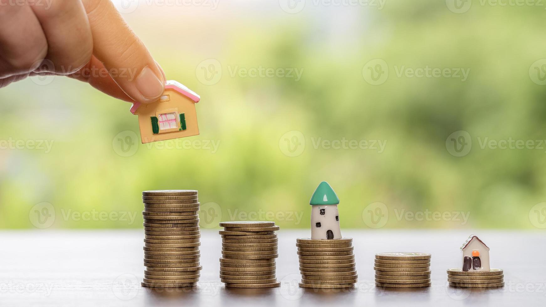 mano poniendo moneda en casa modelo de moneda para ahorrar dinero para comprar casa. planes de ahorro para vivienda, préstamo, inversión, hipoteca, finanzas y banca sobre el concepto de casa. foto