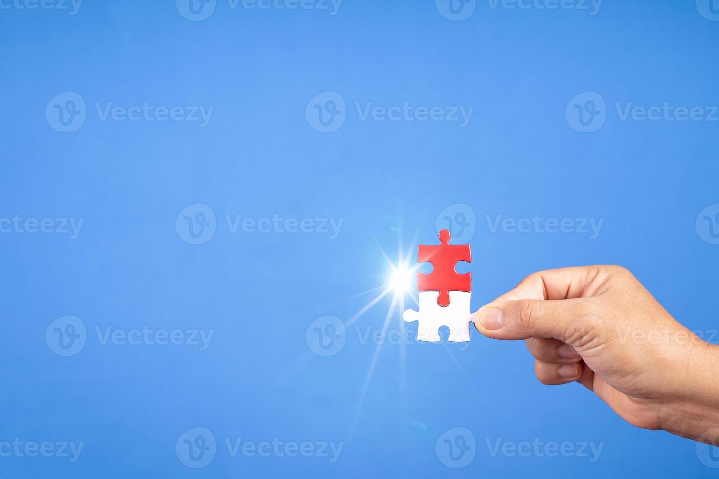 Hands holding jigsaw puzzles piece with clear blue background, success business, solution strategy, teamwork partnership concept photo