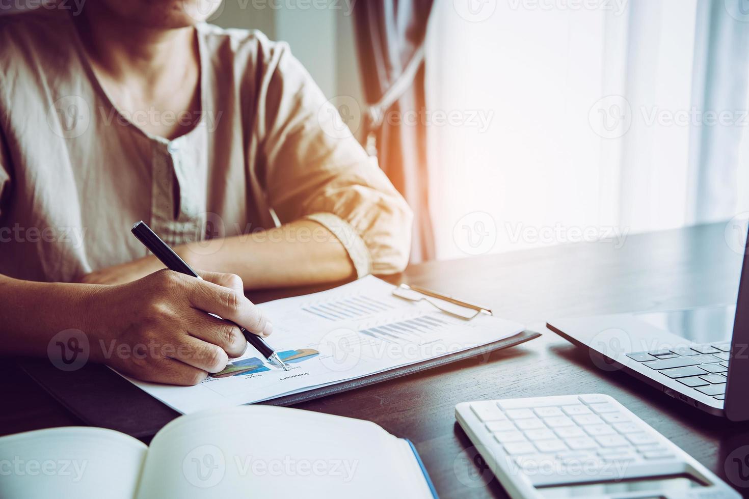 Professional businesswoman working on desk in office. Business woman hand analysis graph document financial on paperwork with chart data and marketing growth report on table. photo