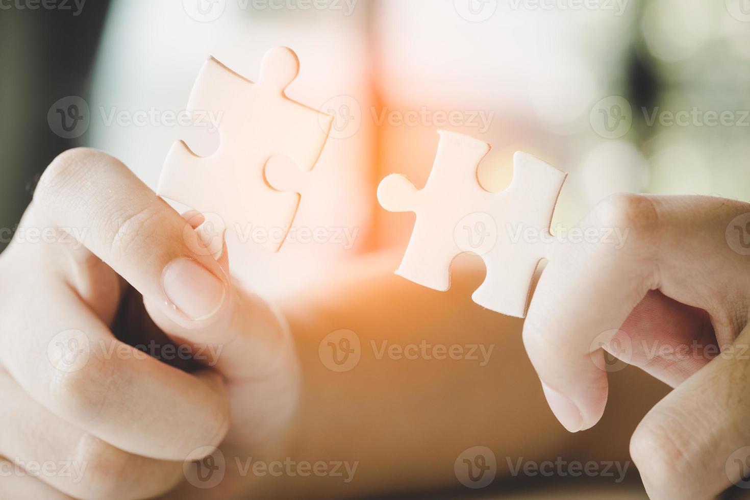 Close up hand holding and playing jigsaw game incomplete. White part of jigsaw puzzle pieces. concepts of problem solving, business, teamwork. photo