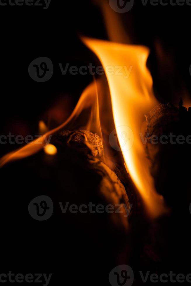 Fire close-up and red orange yellow color detail texture and abstract shape on black background photo