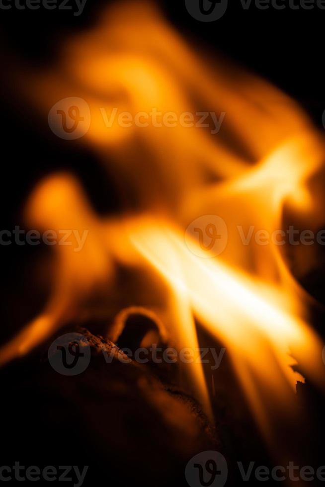 Fire close-up and red orange yellow color detail texture and abstract shape on black background photo