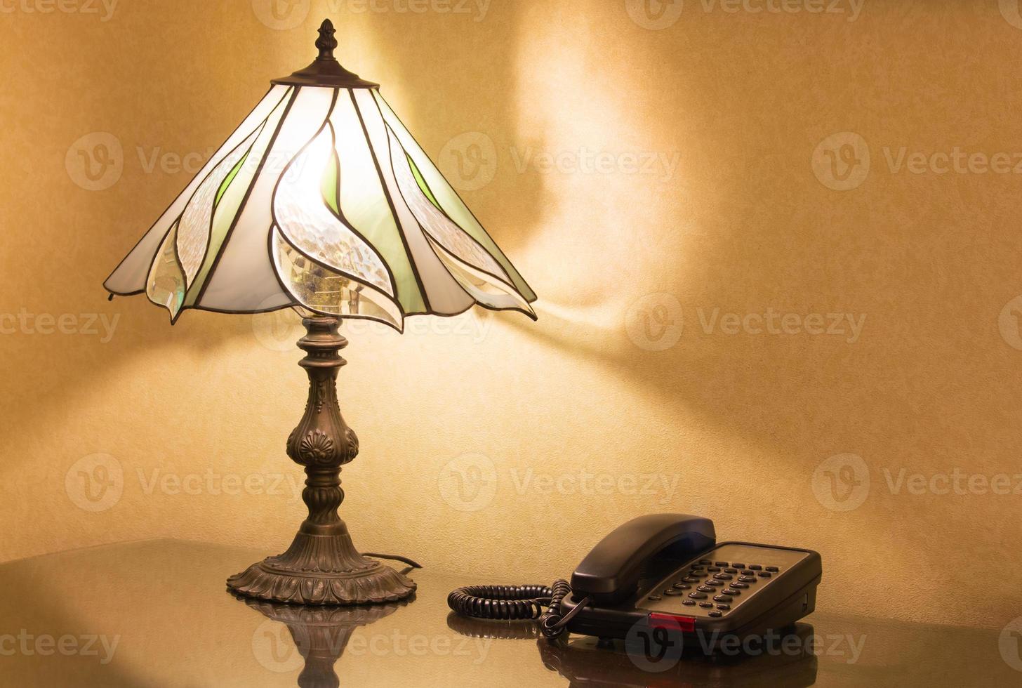 table lamp and phone on desk photo