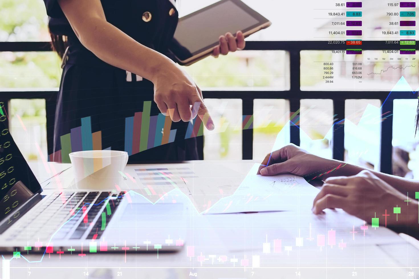 Working women are discussing in their office with stock chart and data overlay photo