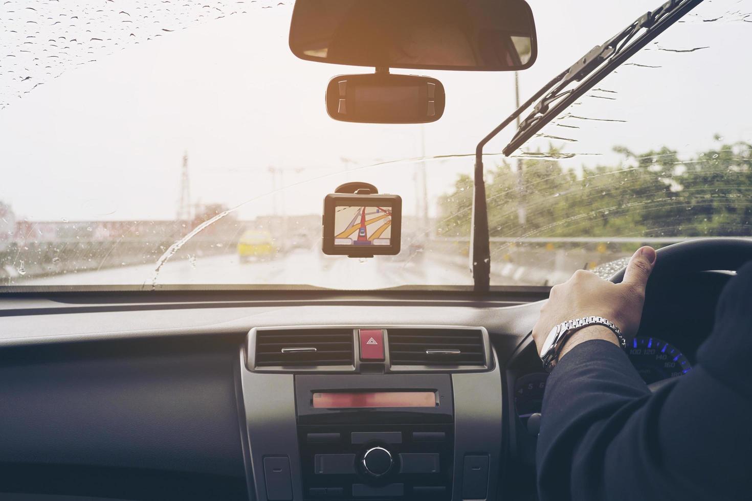 Business man is driving a car in raining day with moving wiper blades photo