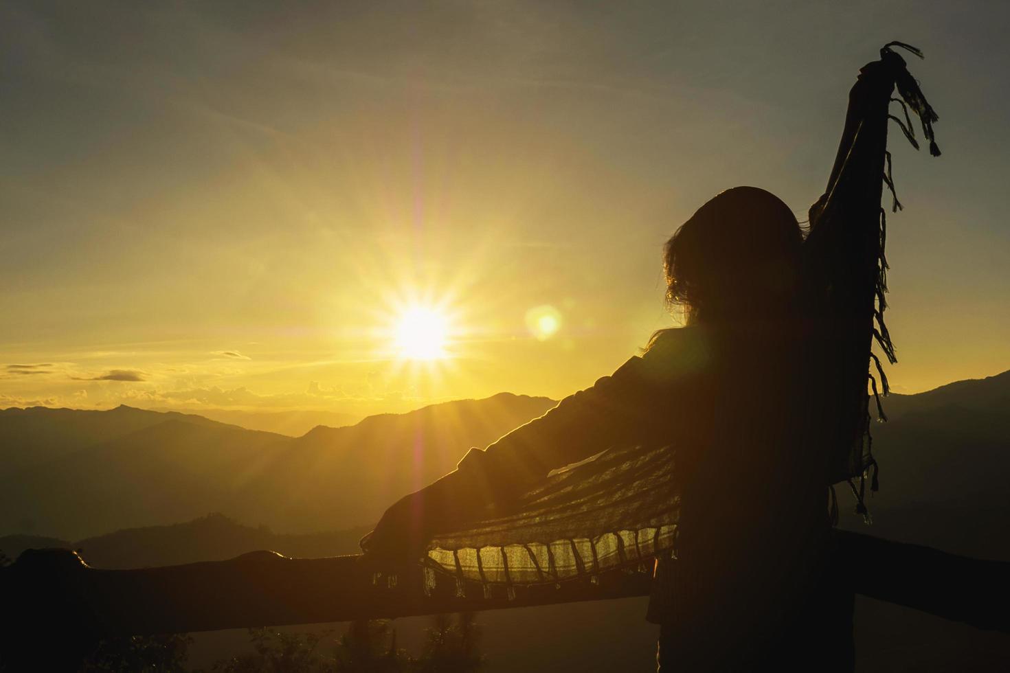 silueta libertad dama feliz levantando su mano hacia el cielo durante el amanecer o el atardecer en el área de tierras altas chiang mai tailandia - gente feliz libertad en el concepto de naturaleza foto