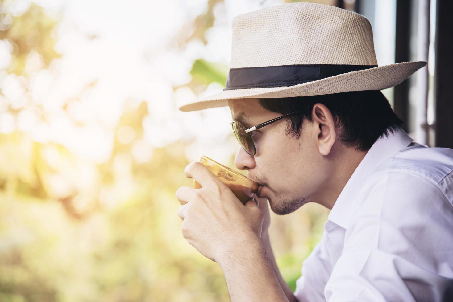 Casual Asian man drink hot coffee happily in nature - people with coffee in nature concept photo