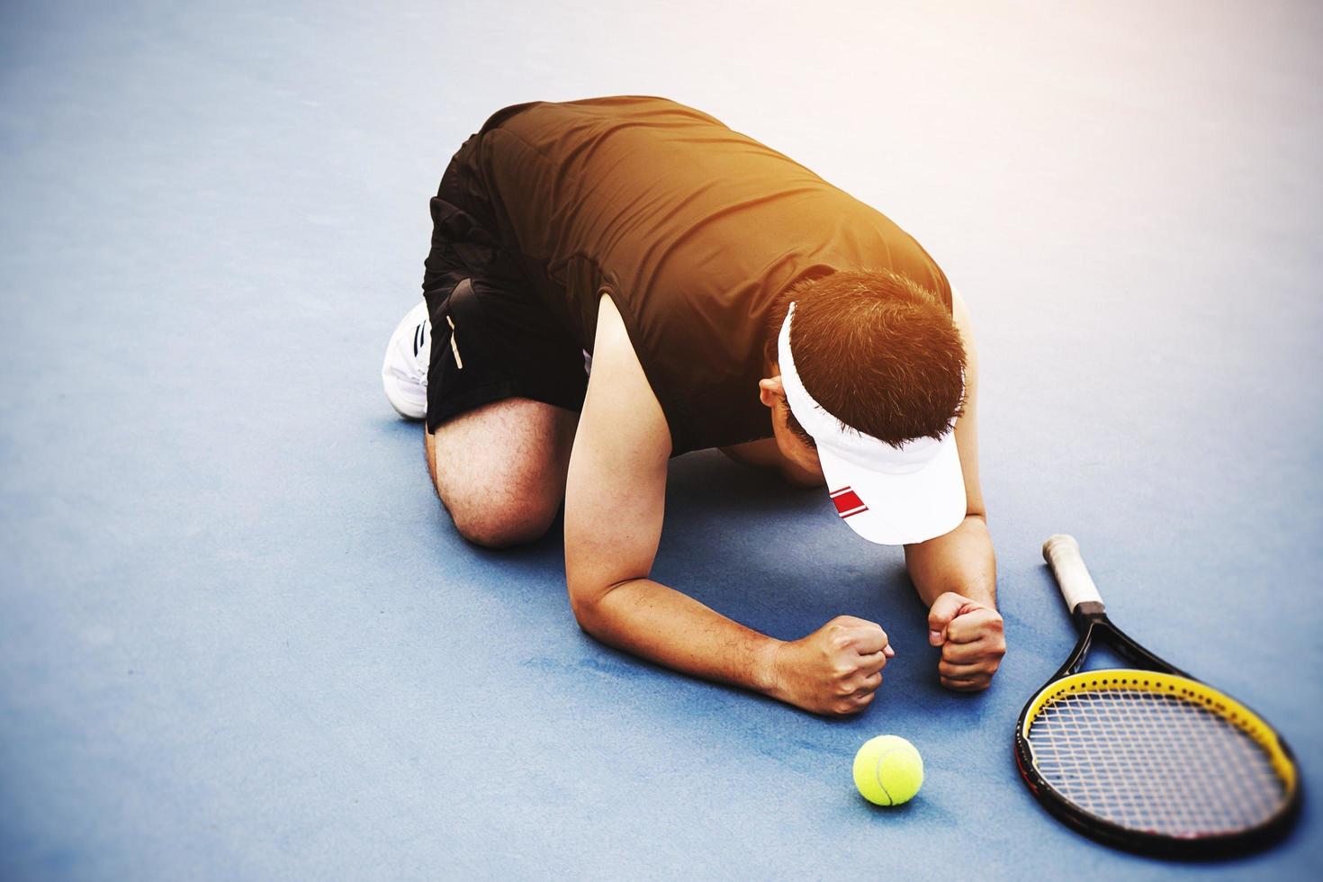 Sad tennis player sitting in the court after lose a match photo