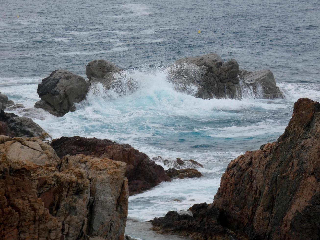 Rough sea, waves crashing against the rocks photo