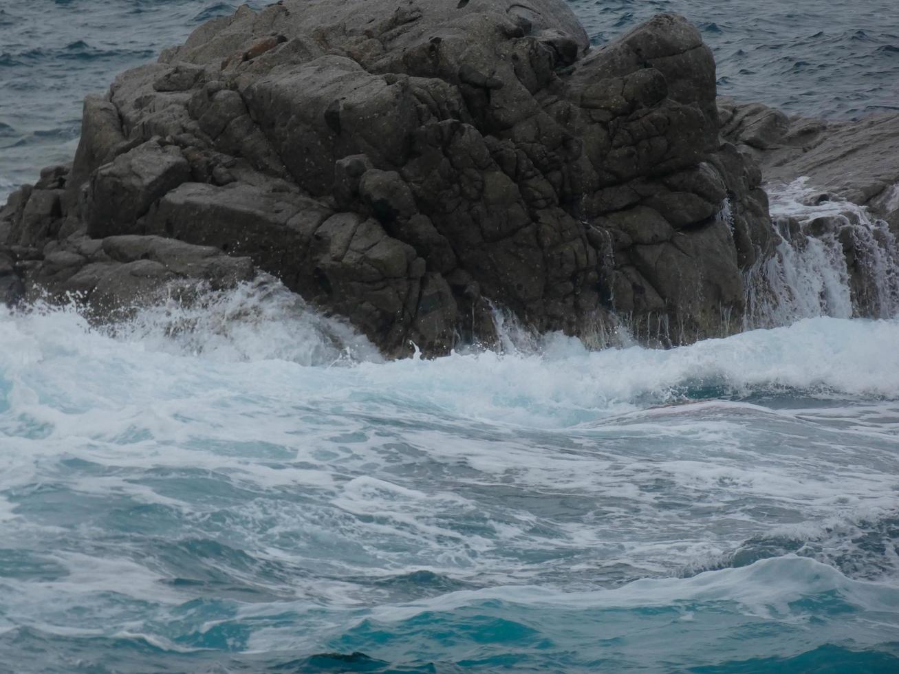 Rough sea, waves crashing against the rocks photo