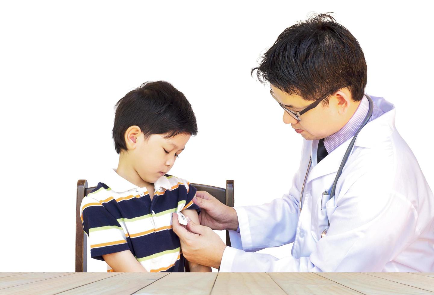Sick Asian boy being examined by male doctor isolated over white photo