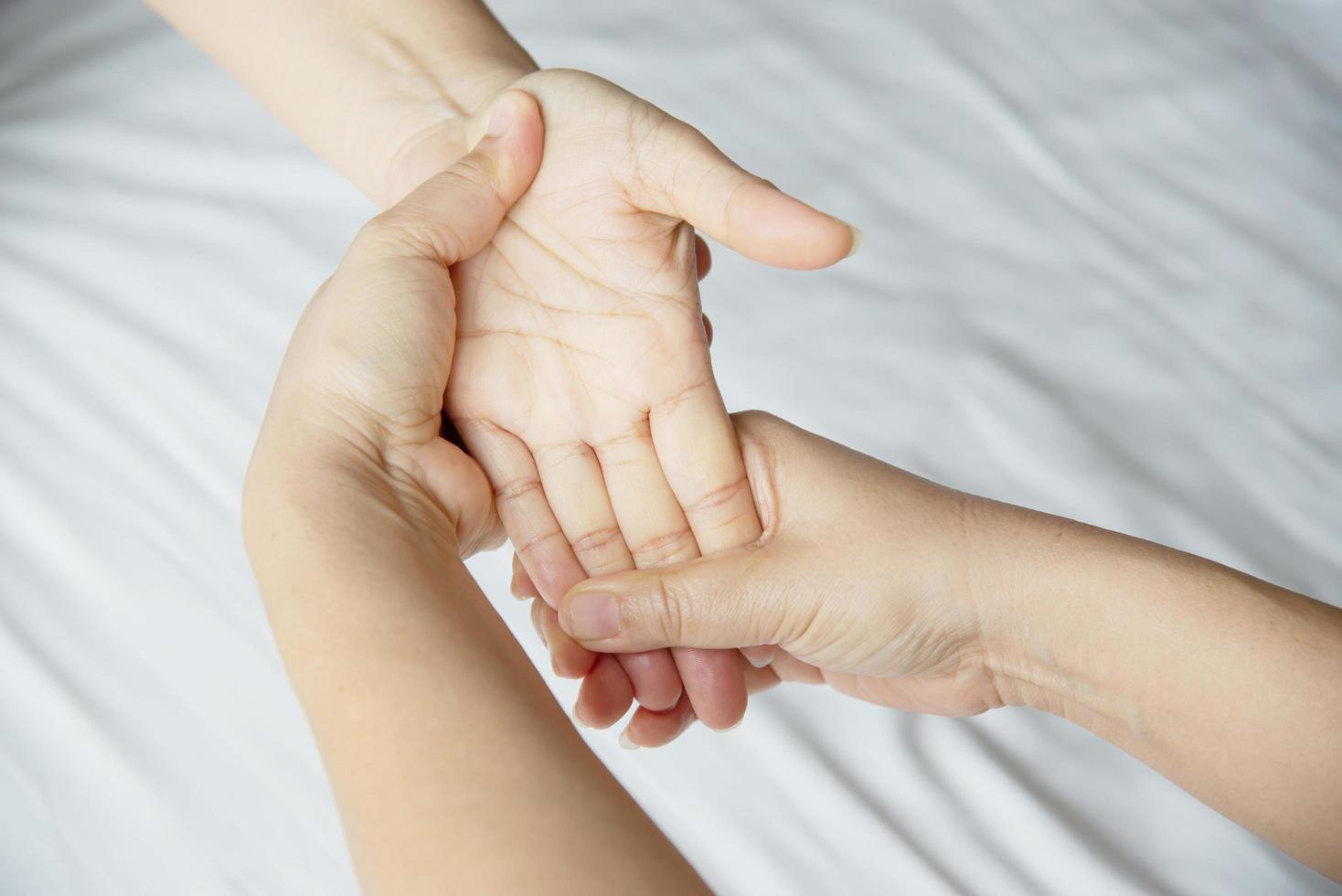 Hand spa massage over clean white bed background - people relax with hand massage service photo