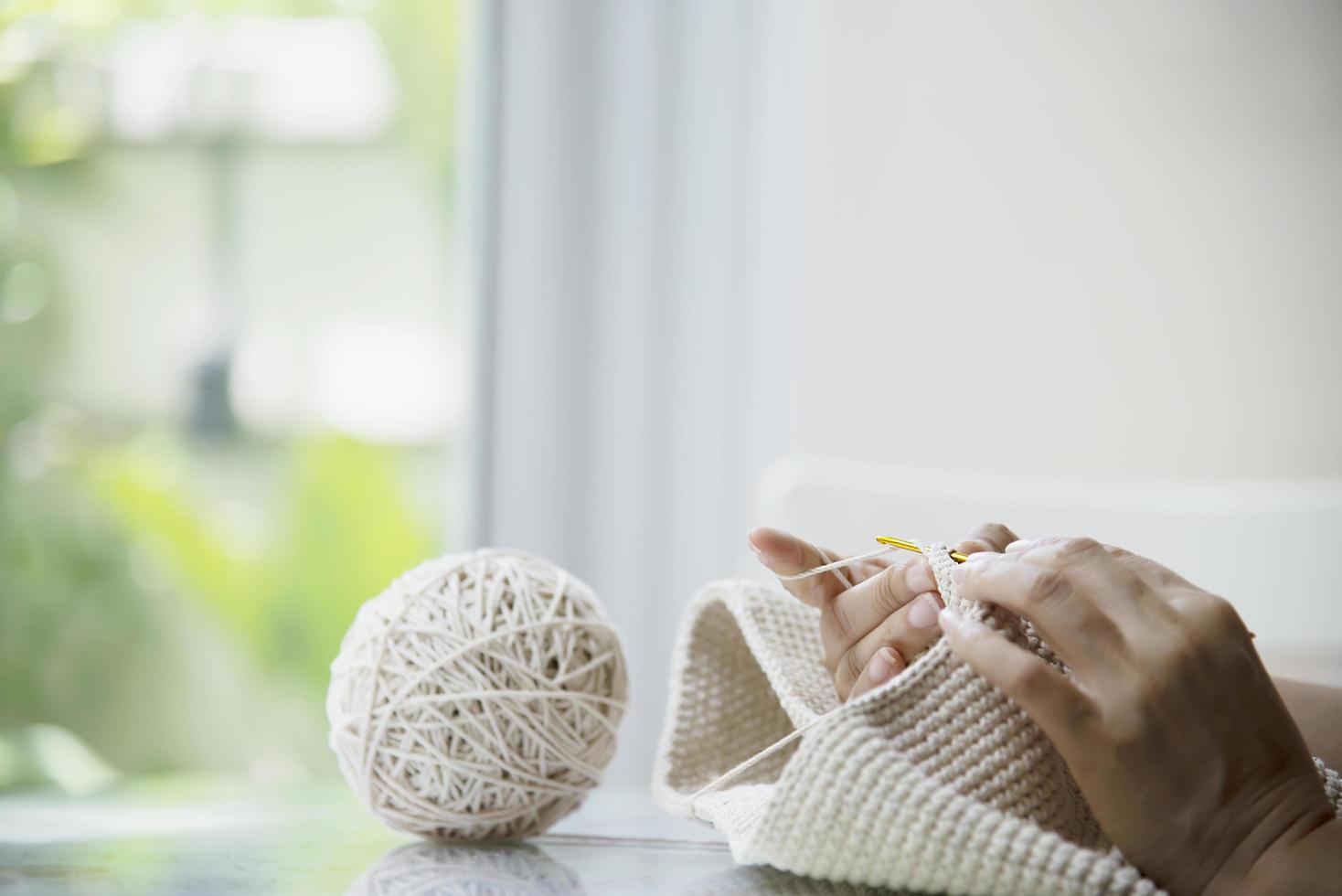 Woman's hands doing home knitting work - people with DIY work at home concept photo