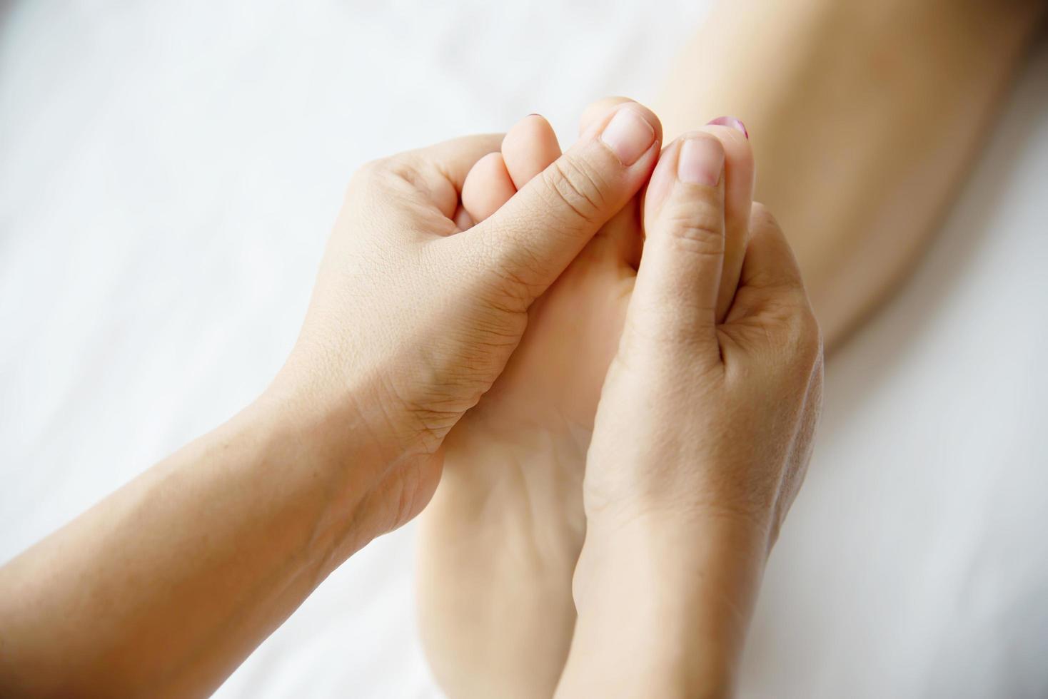 Woman receiving foot massage service from masseuse close up at hand and foot - relax in foot massage therapy service concept photo