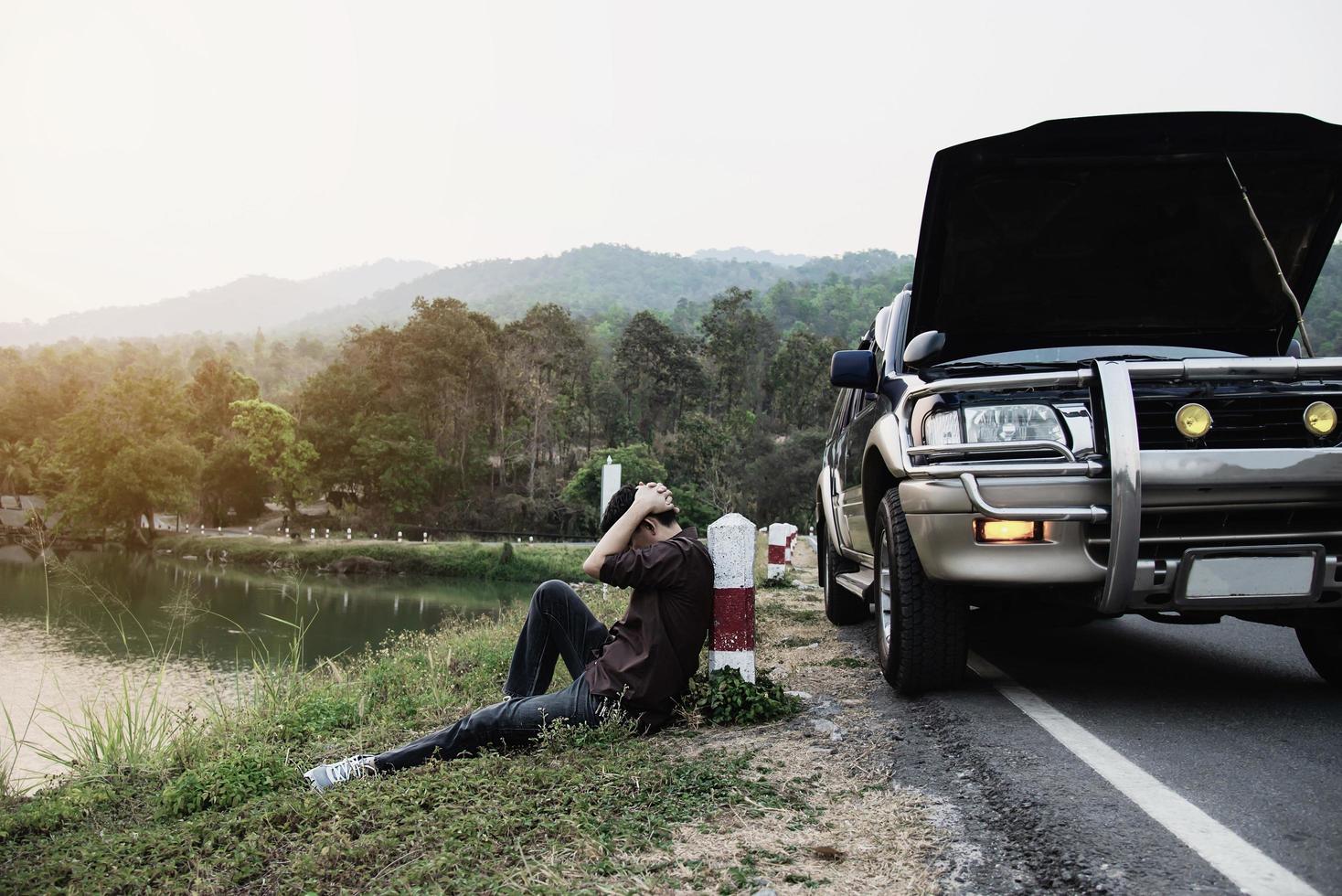 Man try to fix a car engine problem on a local road Chiang mai Thailand - people with car problem transportation concept photo