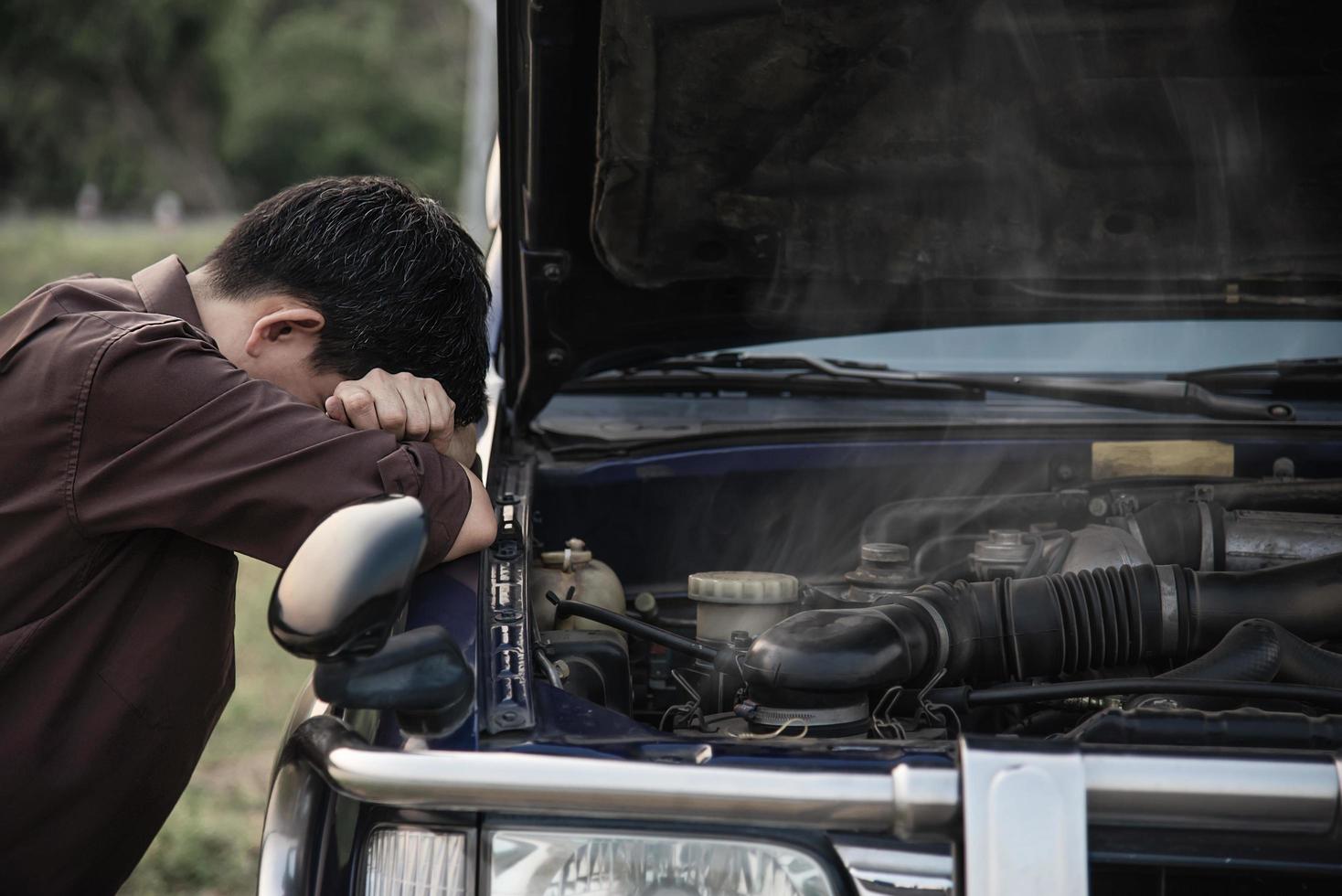 Man try to fix a car engine problem on a local road Chiang mai Thailand - people with car problem transportation concept photo