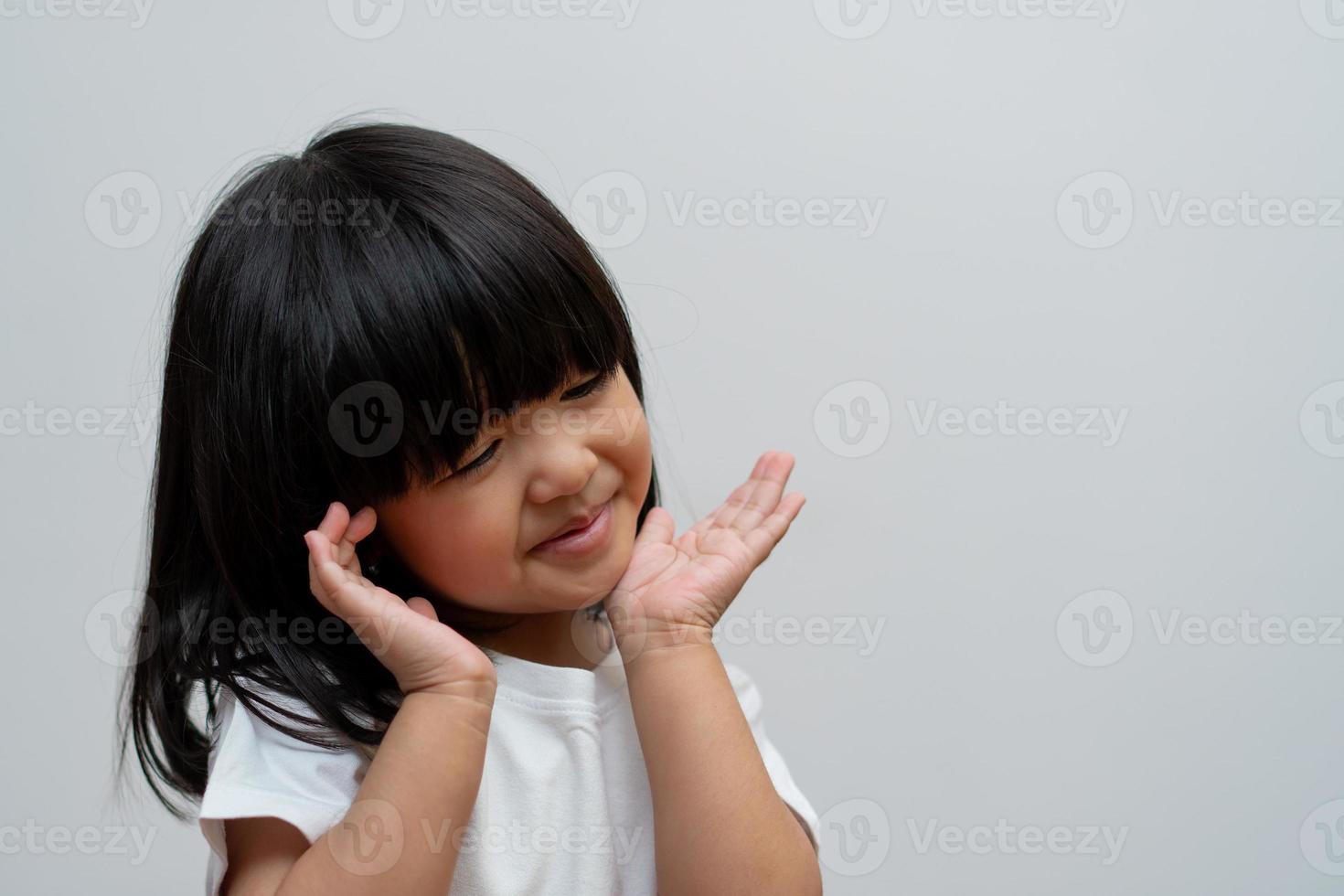 Portrait of happy and funny Asian child girl on white background, a child looking at camera. Preschool kid dreaming fill with energy feeling healthy and good concept photo