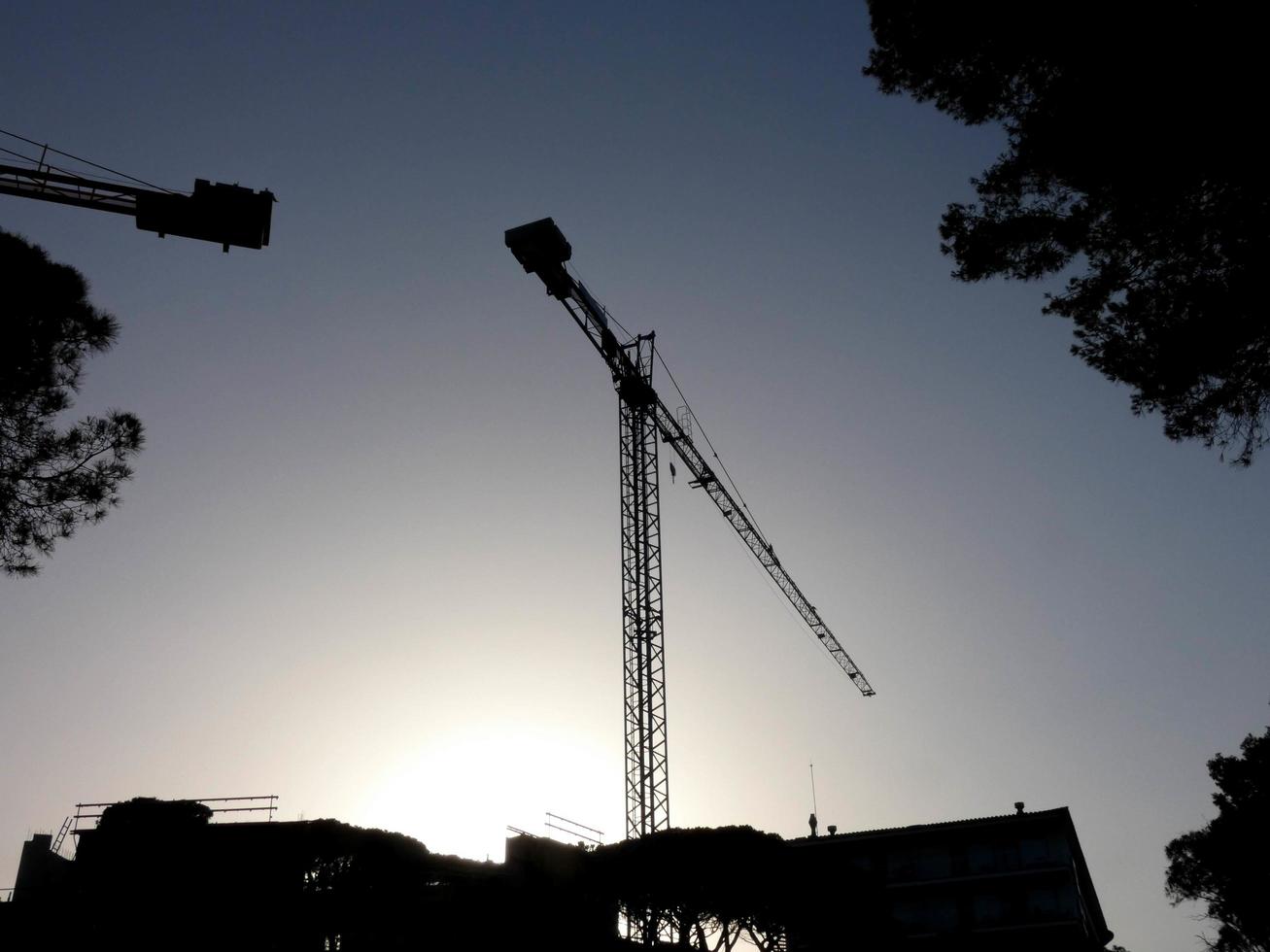 grúa en el trabajo en un sitio de construcción que transporta materiales foto