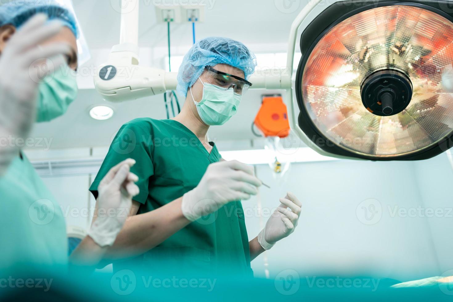 Low Angle Shot of Professional surgeons team performing surgery in operating room, surgeon, Assistants, and Nurses Performing Surgery on a Patient, health care cancer and disease treatment concept photo