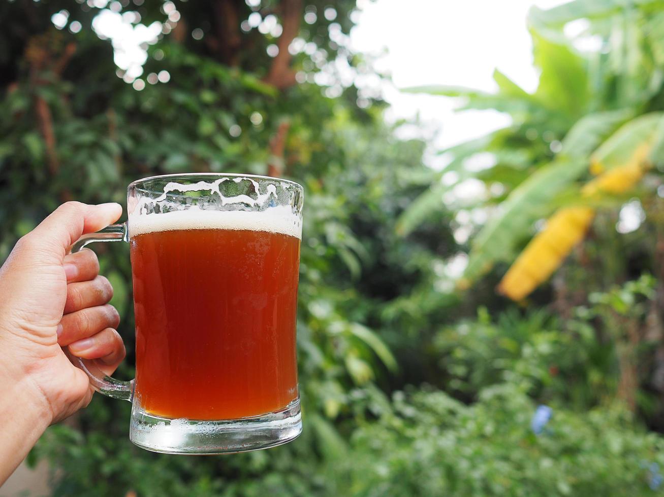 Close-up of hand holding a glass of craft beer photo