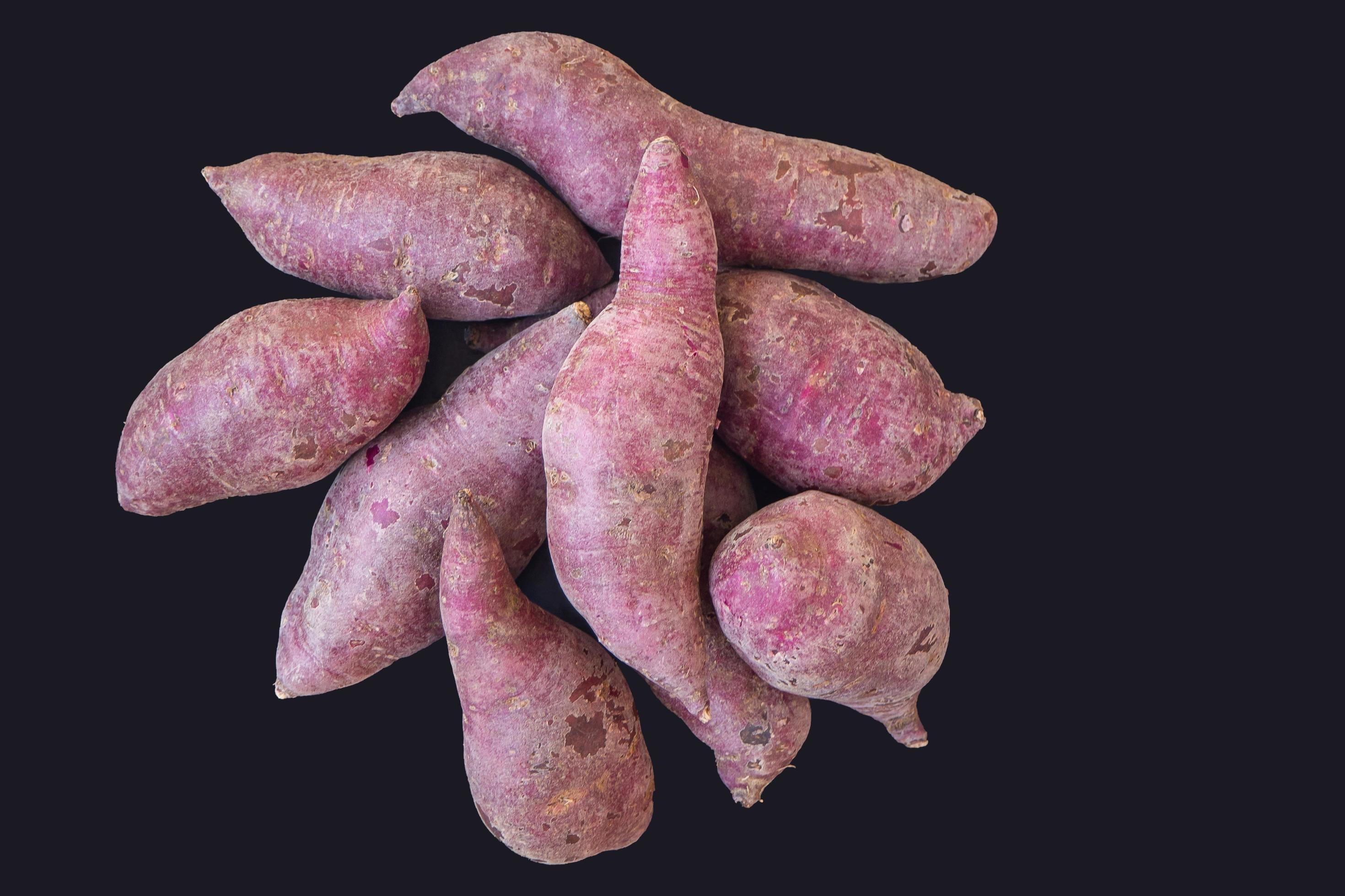 Closeup of fresh purple yams pile on black background 10204400 Stock