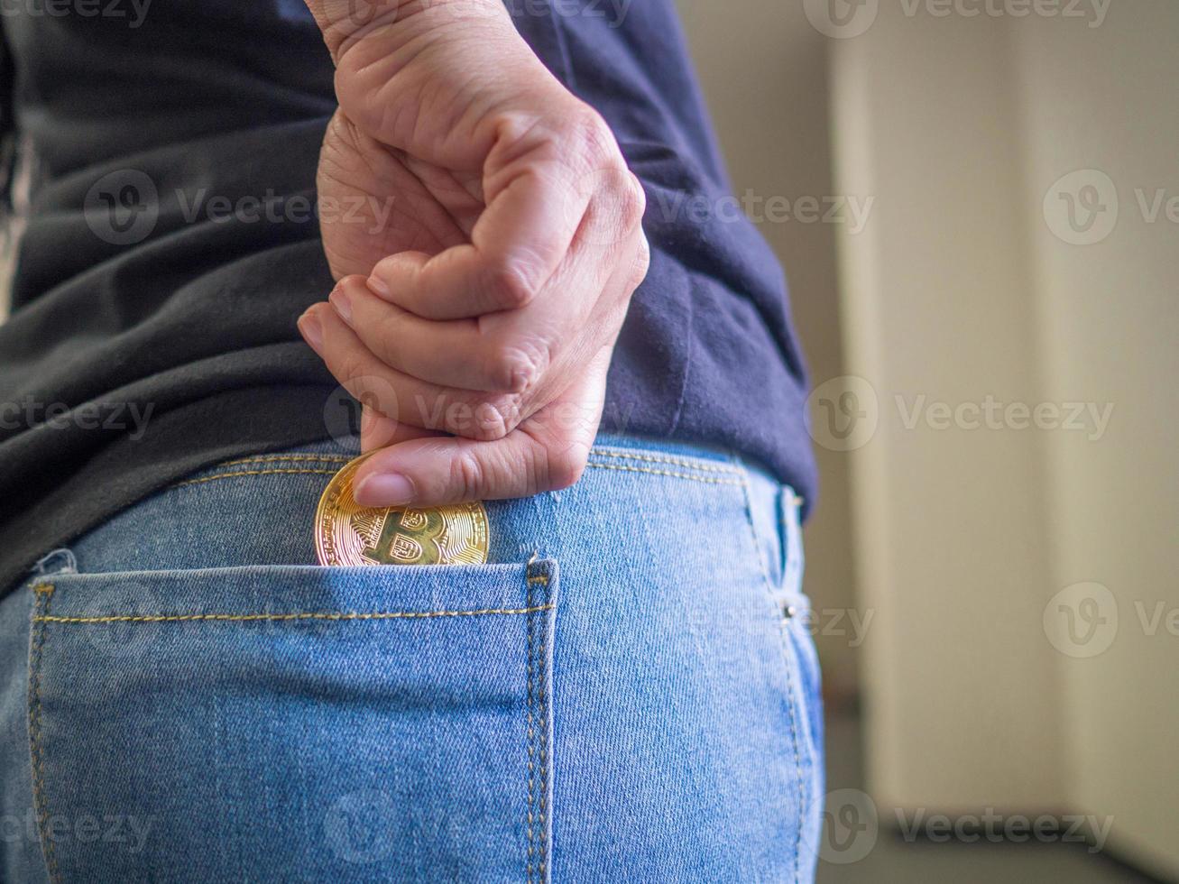 Back view of woman's hand holding bitcoin with blurred background photo