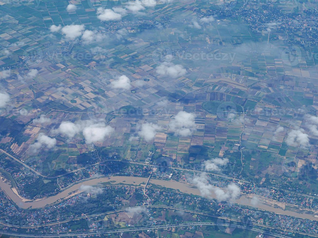 vista aérea del campo agrícola y el río visto a través de la ventana del avión foto