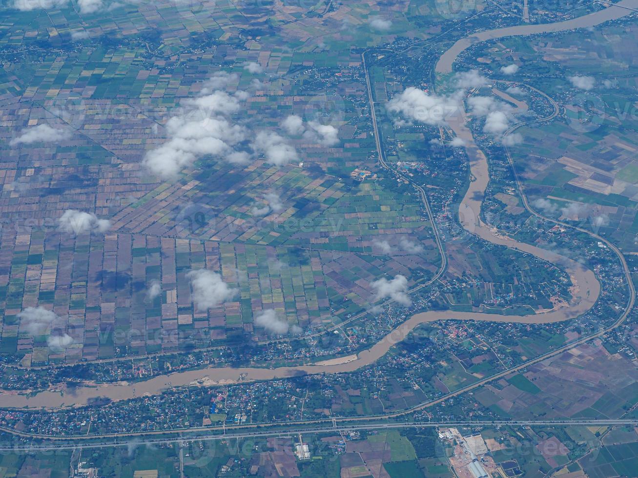 Aerial view of agricultural field and river seen through airplane window photo