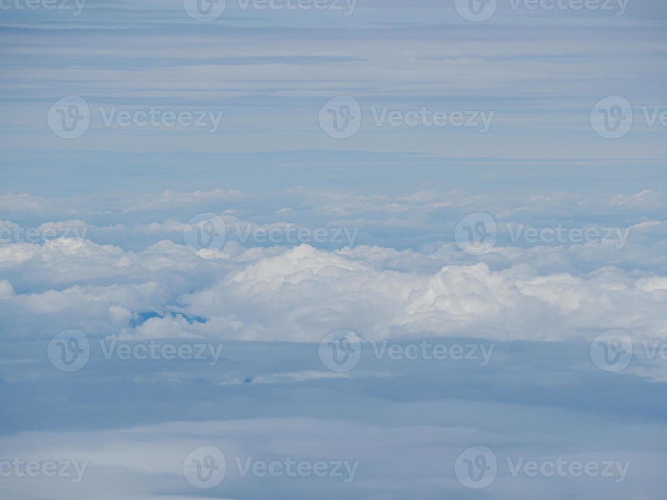 Aerial view of cloudscape seen through airplane window photo