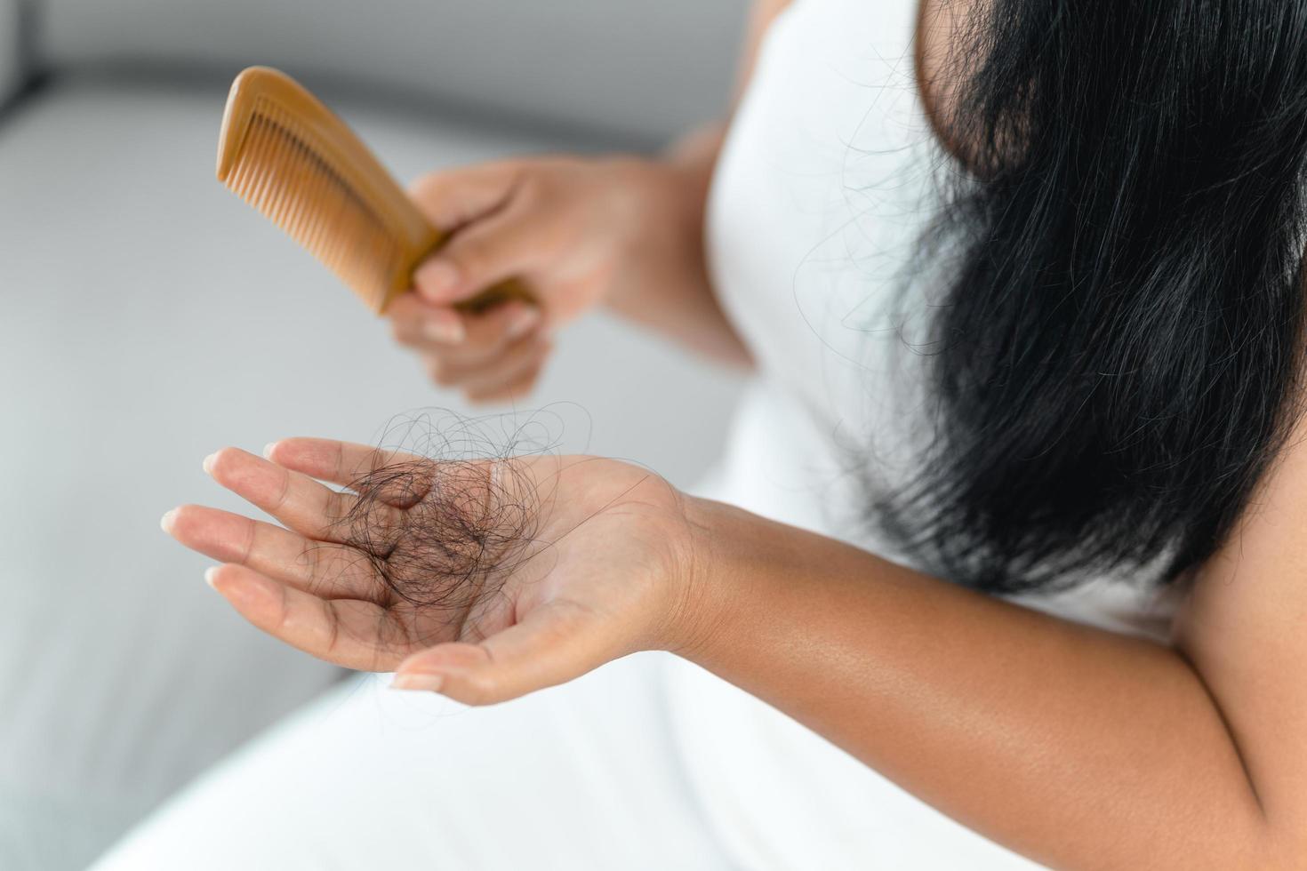 problema de caída de cabello. mujer asiática con problema de peine y cabello. pérdida de cabello del peine. conceptos de belleza y cuidado del cabello. foto