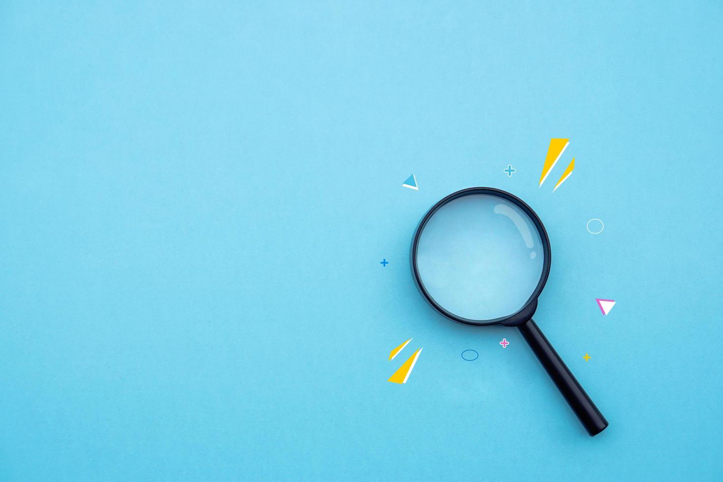 Magnifying glass on blue background in pastel colours. photo