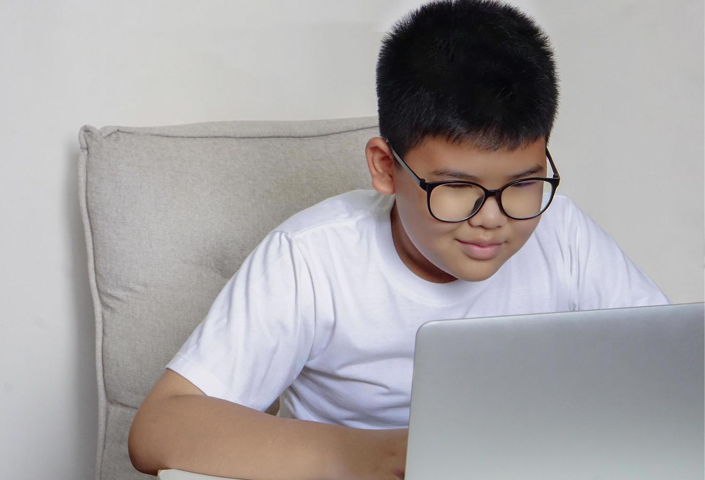 Close up face cute boy having fun watching laptop. Education, learning and technology concept. photo